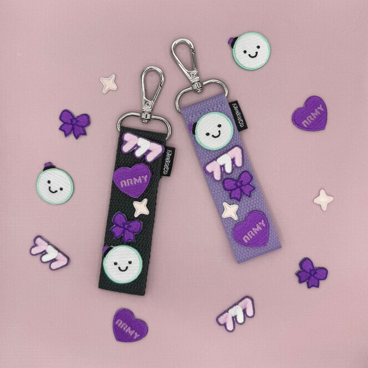 This image features two DIY fabric strap kits, ideal for personalizing accessories like bags, phones, and lightsticks. Each strap kit is adorned with charming iron-on patches, showcasing cute character designs in purple and black color themes.