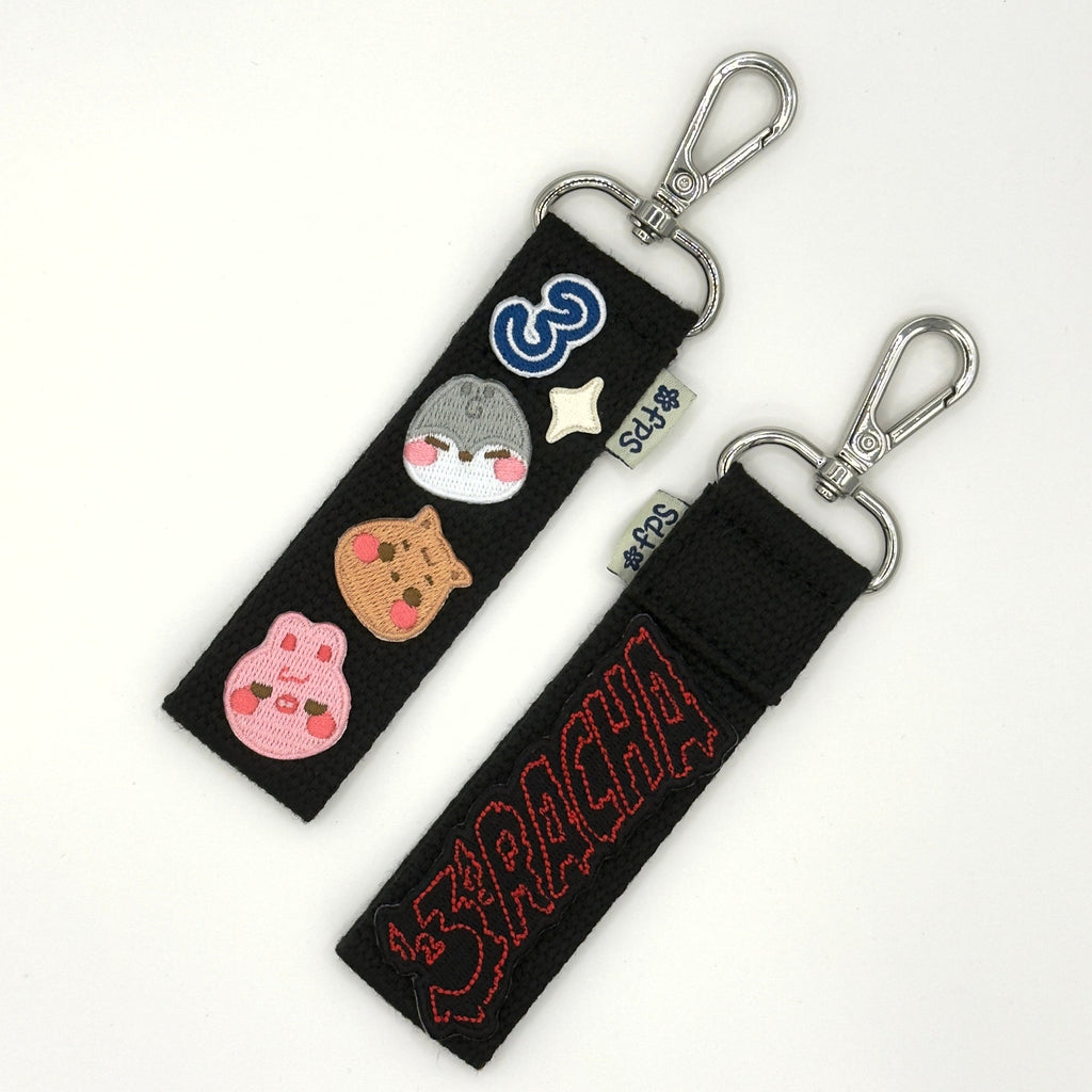 Two black keychains with colorful designs on a white background